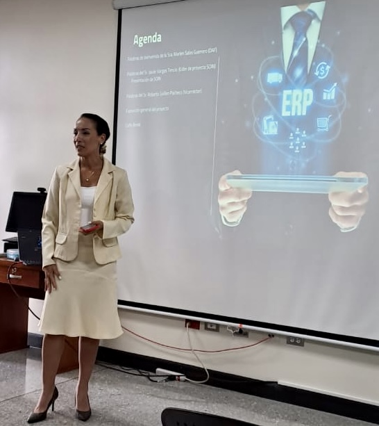 Fotografía de doña Marlen Salas presentando el proyecto, de fondo la presentación de power Point sobre ERP.